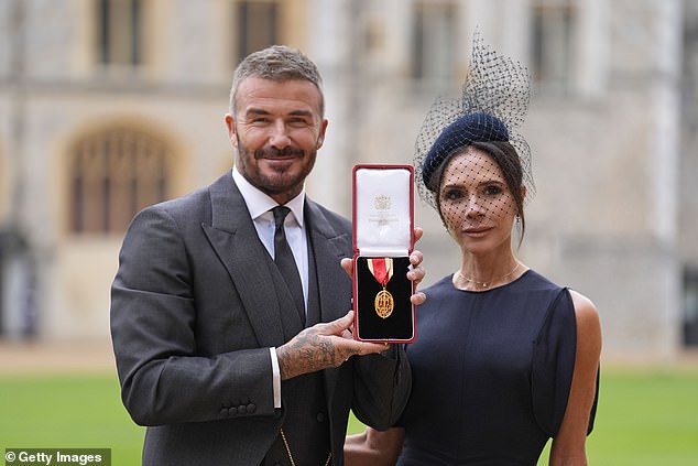 England footballer David Beckham (left) with his wife Victoria (right) posing with his medal after he was knighted last week
