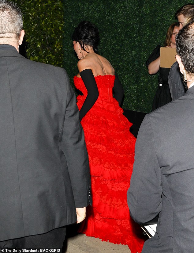 Kris was decked out in a sumptuous strapless crimson gown with a billowing skirt that featured cascading rows of frills, culminating in a train