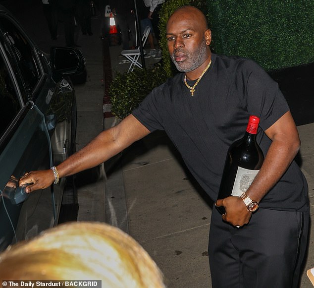 His understated outfit was jazzed up with jewelry, including what appeared to be a gold watch and matching cross, as well as a glistening bracelet