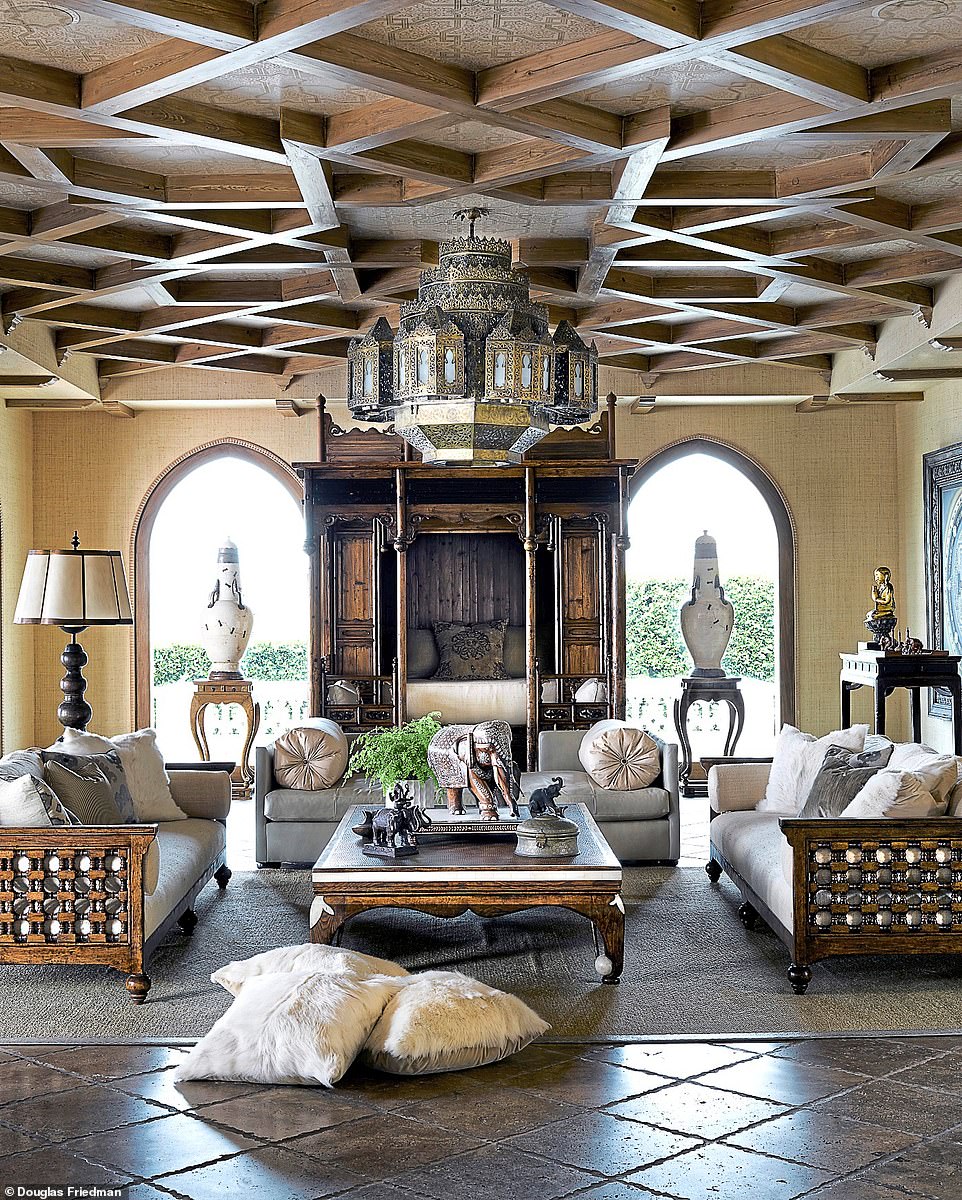 The living room is anchored by an 18th-century opium bed, the walnut sofas were custom designed for the space, and the table was once a Chinese bed. On the wall, just in frame, is a mandala Cher brought back from Tibet.