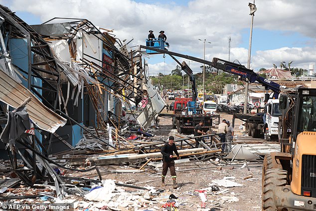 People work removing the debris caused by the tornado with winds of up to 155mph hour