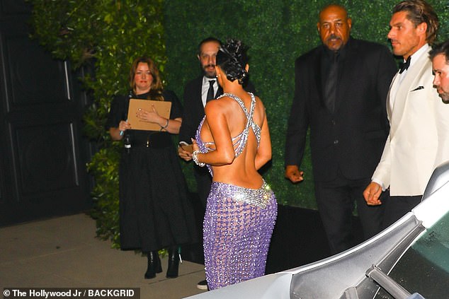 Kim Kardashian wore a clinging backless number which allowed her to showcase her world-famous curves to full advantage as she strode into her mother's blowout bash