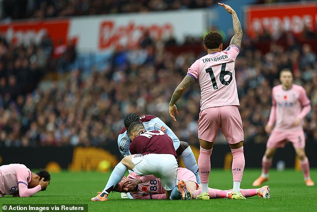 Aston Villa and Bournemouth players attend to the stricken duo before medical aid arrived