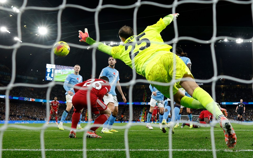 Virgil van Dijk of Liverpool scores a goal past Gianluigi Donnarumma of Manchester City as Andrew Robertson of Liverpool ducks, which is later disallowed due to offside.