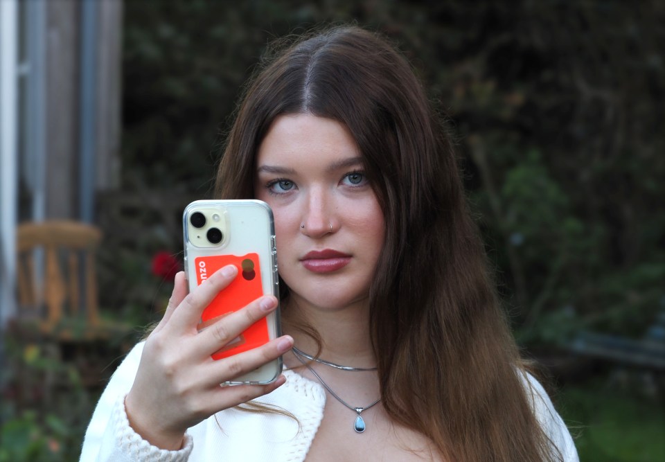 A 17-year-old girl holding a smartphone up to the camera.