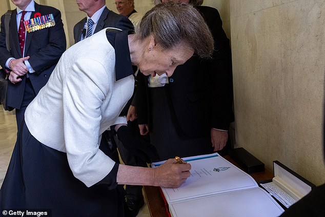 The Princess Royal, 75, is pictured signing a book at the ANZAC Memorial in Sydney during her visit on Sunday