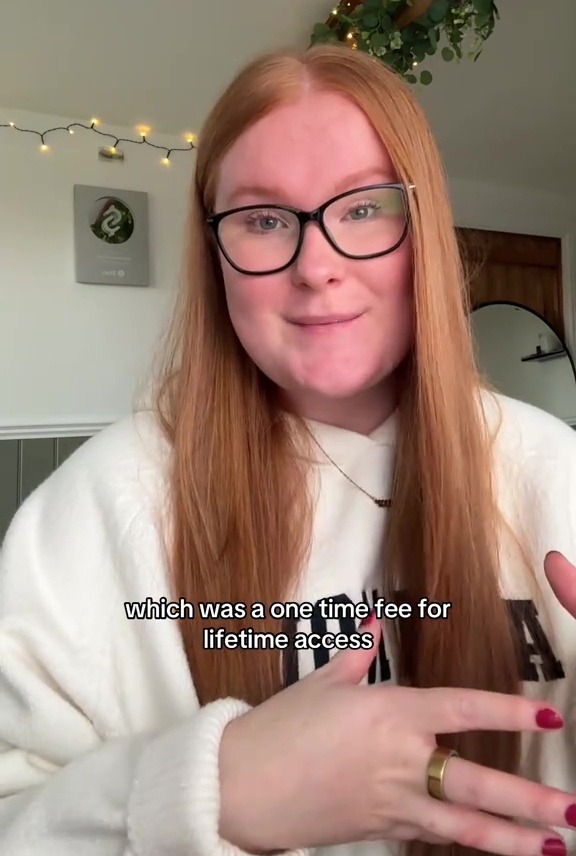 A young woman with red hair and glasses talking, with text overlay.