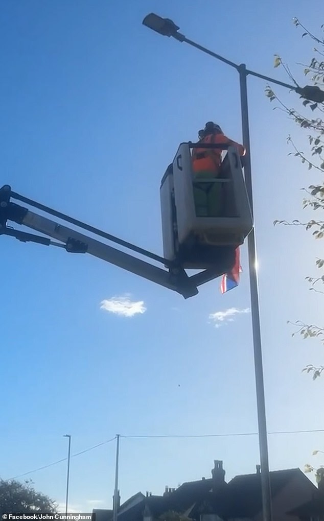 Video captured council workers in high visibility jackets using a cherry picker to remove flags in Shrewsbury after the storm, which hit the UK with 80mph gusts on October 3 and 4