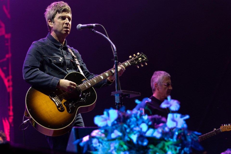 Noel Gallagher performing live with a guitar at Hardwick Festival.