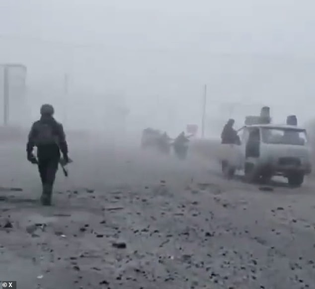 The video, shared by the Kyiv Post, shows soldiers clinging to battered vehicles and motorbikes as they roll down a debris-strewn road