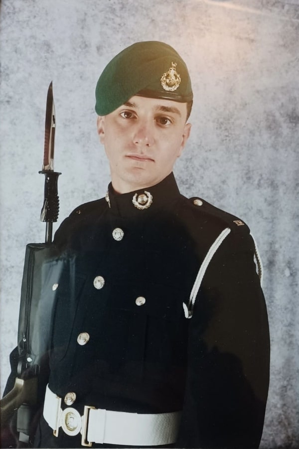 Joshua Houghton in military uniform with a rifle and bayonet.