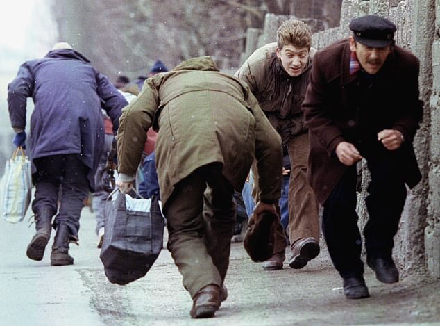 People run for cover as they pass an area of heavy Serb sniper fire in the besieged Bosnian capital