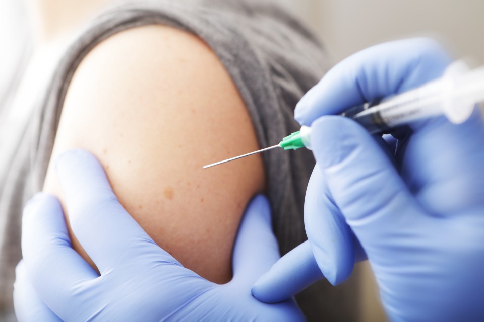 Close-up of a person receiving a vaccine shot in the arm.