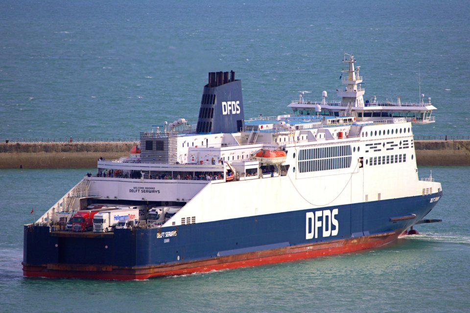 DFDS ferry sailing near Dover with a clear blue sky and calm sea.