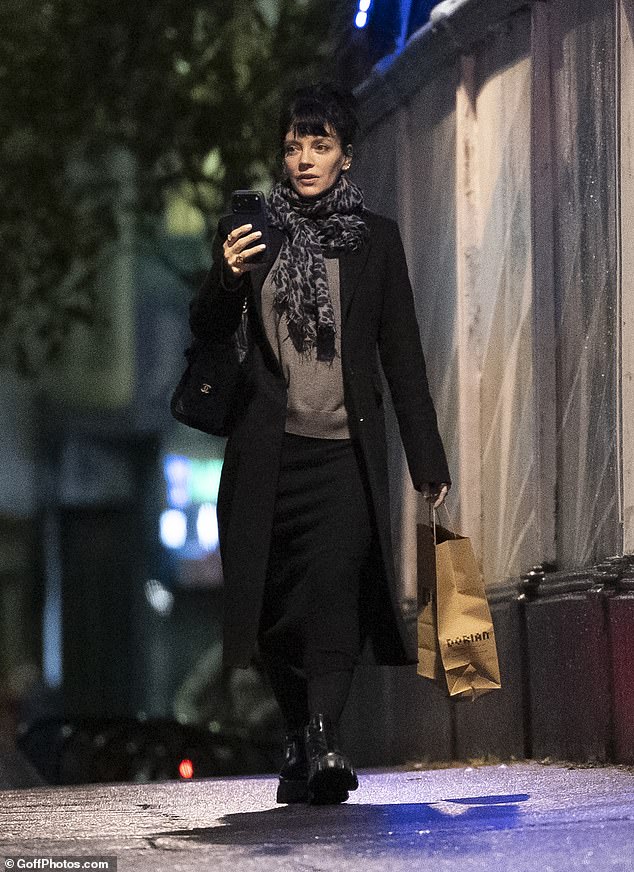 Lily wrapped up warm in a black coat as she left the venue