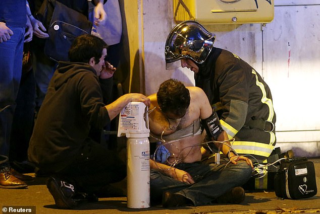 French fire brigade members aid an injured individual near the Bataclan concert hall following fatal shootings in Paris, France, November 13, 2015