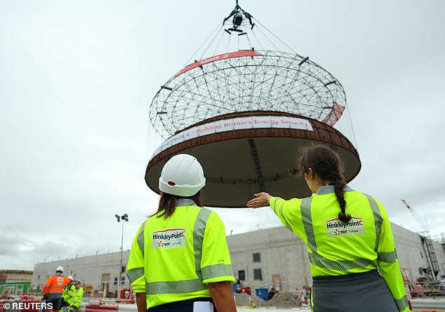 It's hoped SMRs will be quicker to build than more traditional plants such as Hinkley Point C, a nuclear power station under construction in Somerset. Pictured, workers stand near a 245-tonne domed roof being place on the second reactor building at Hinkley Point C, July 17, 2025