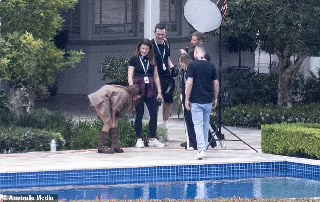 Alex was spotted fixing her knee high boots while chatting to crew members