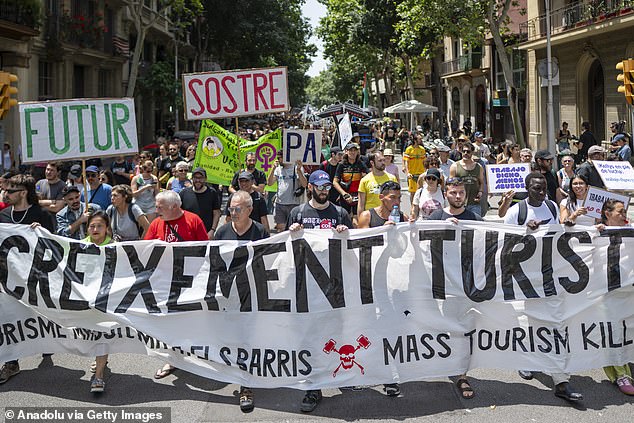 Demonstrators march through the streets of Barcelona during an anti-tourism protest in June
