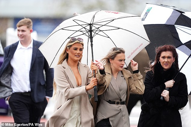 Racegoers in rainy conditions during Countryside Day at Cheltenham Racecourse today