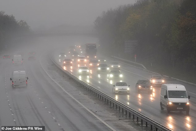 Motorists travel through rain and spray on the M11 near Harlow in Essex this afternoon
