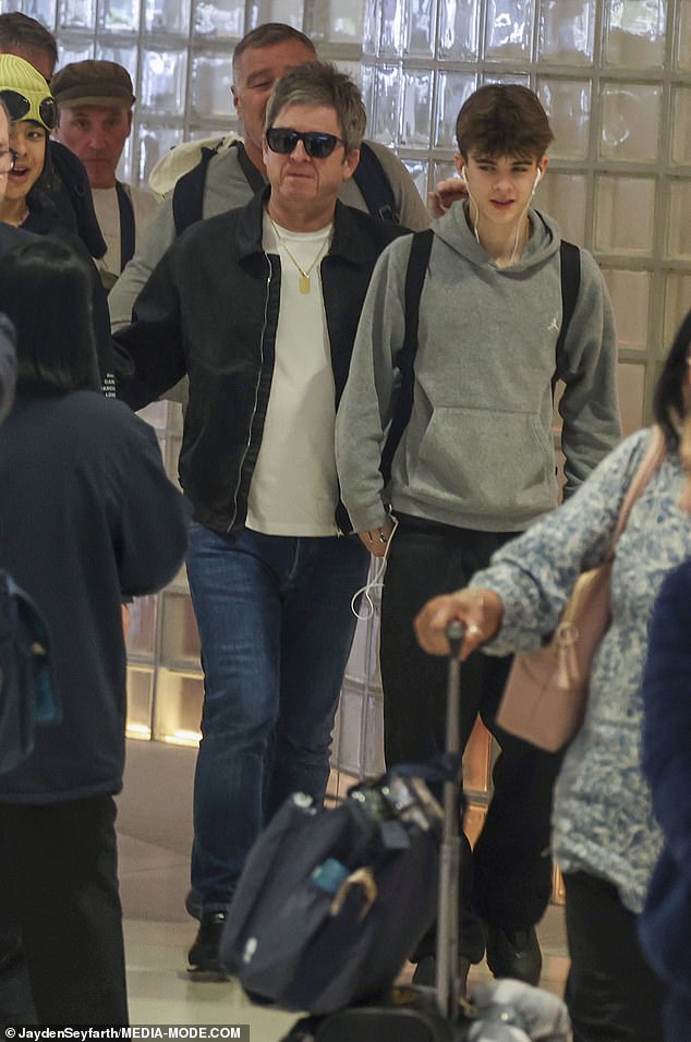 The 58-year-old rocker cut a relaxed figure in dark sunglasses, jeans and a black jacket as he made his way through the terminal alongside one of his sons