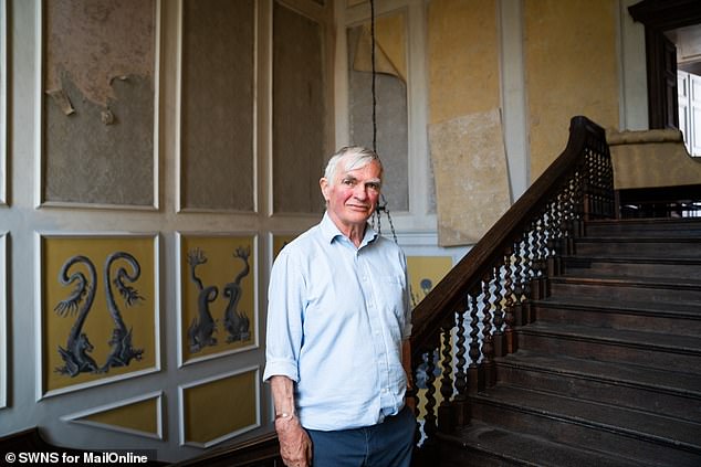 Francis 'F*****' Fulford is standing on a large grand staircase in a chamber as cavernous as it is gloomy
