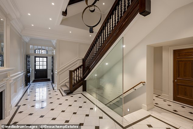 Pictures inside the house show chequered marble flooring, a guest cloakroom and a grand central staircase around an artistic chandelier