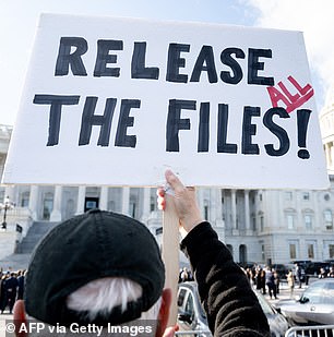 A protester holds a sign related to the release of the Jeffrey Epstein case files outside the US Capitol in Washington, D.C.