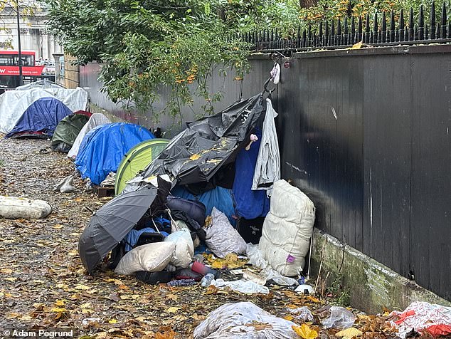 The row of tents back up against the wall of the iconic house while a child's shoe could be seen hanging from one