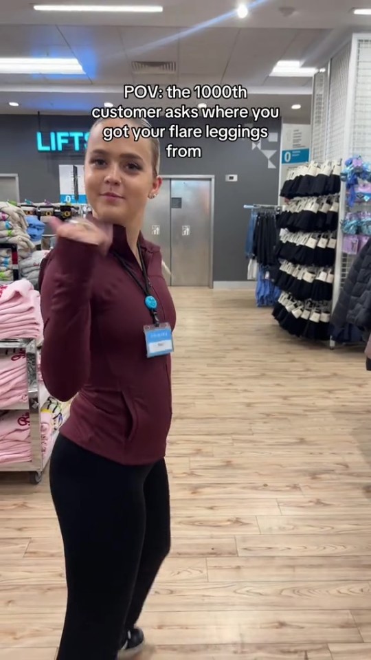 A young woman, wearing a maroon jacket and black leggings, looks at the camera while standing in a store. Text reads: "POV: the 1000th customer asks where you got your flare leggings from."