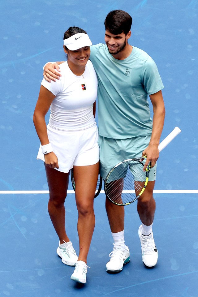 Emma Raducanu and Carlos Alcaraz at the net after a tennis match.