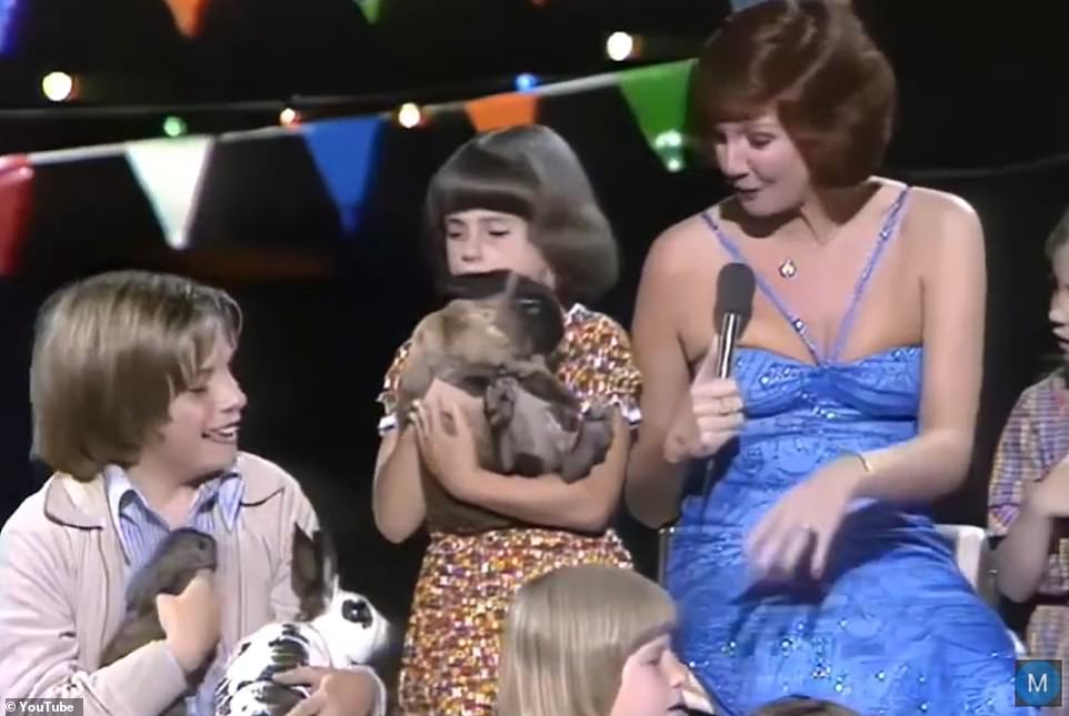 In the music video, Cilla sits among a group of children holding rabbits as she performs the moving song