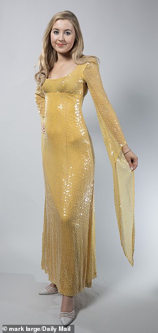 It features a butter yellow colour and long sleeves, which hang below the arms to form a triangle