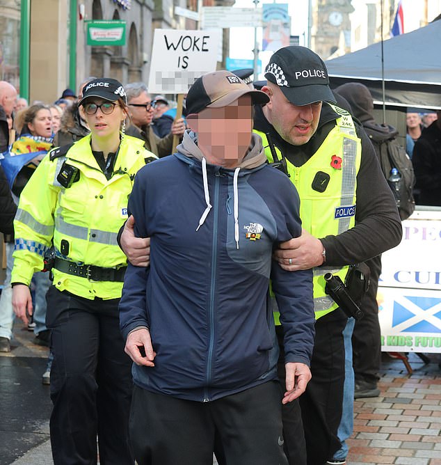 An anti-migrant protester is led away from Sunday's demonstration in Inverness