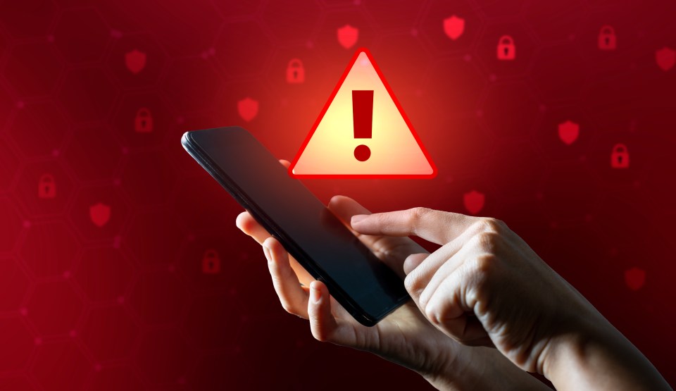 Hands interacting with a smartphone with an alert icon and cybersecurity symbols on a red background.