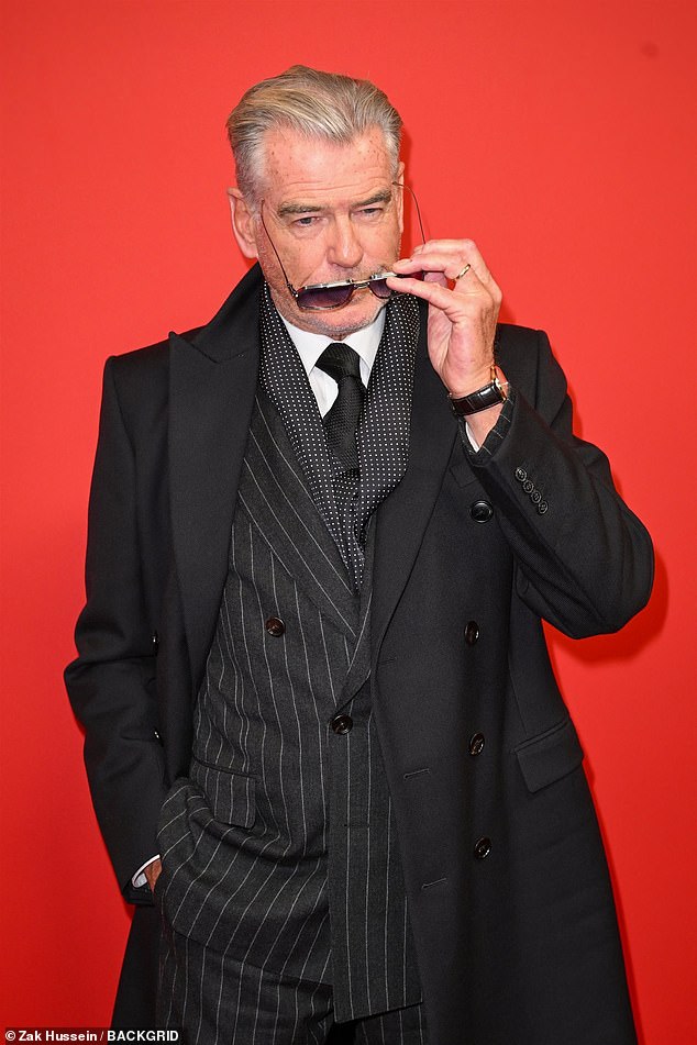 Pierce rocked a pinstripe suit, which he teamed with a tailored coat and purple aviators