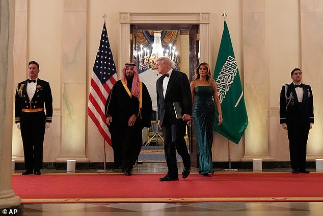 Saudi Crown Prince Mohammed bin Salman (left) enters the Cross Hall alongside President Donald Trump (center) and First Lady Melania Trump (right) ahead of the Saudi dinner in the East Room Tuesday night