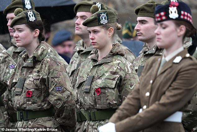The 'couple' sported matching solemn expressions as they marched alongside fellow cadets in camouflage ensembles, all wearing red poppies, walking from Holy Trinity Church to the War Memorial in town, where wreathes are laid down