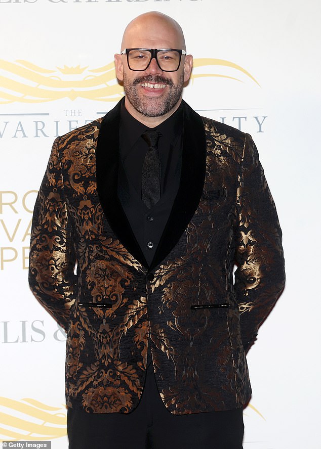 Comedian Tom Davis opted for a ornate gold patterned suit jacket