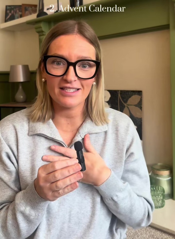 A person wearing glasses and a gray sweater holds a small black microphone and talks to the camera, with the text "2. Advent Calendar" overlayed.