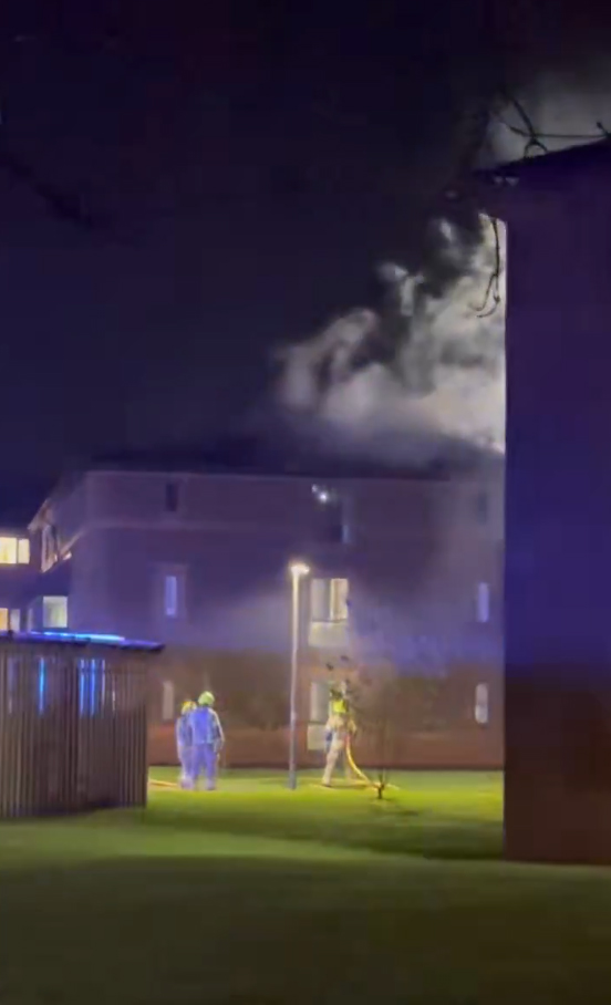 Firefighters working to put out a fire at the Arthur Vick residence in the University of Warwick, with smoke billowing from the top floors.