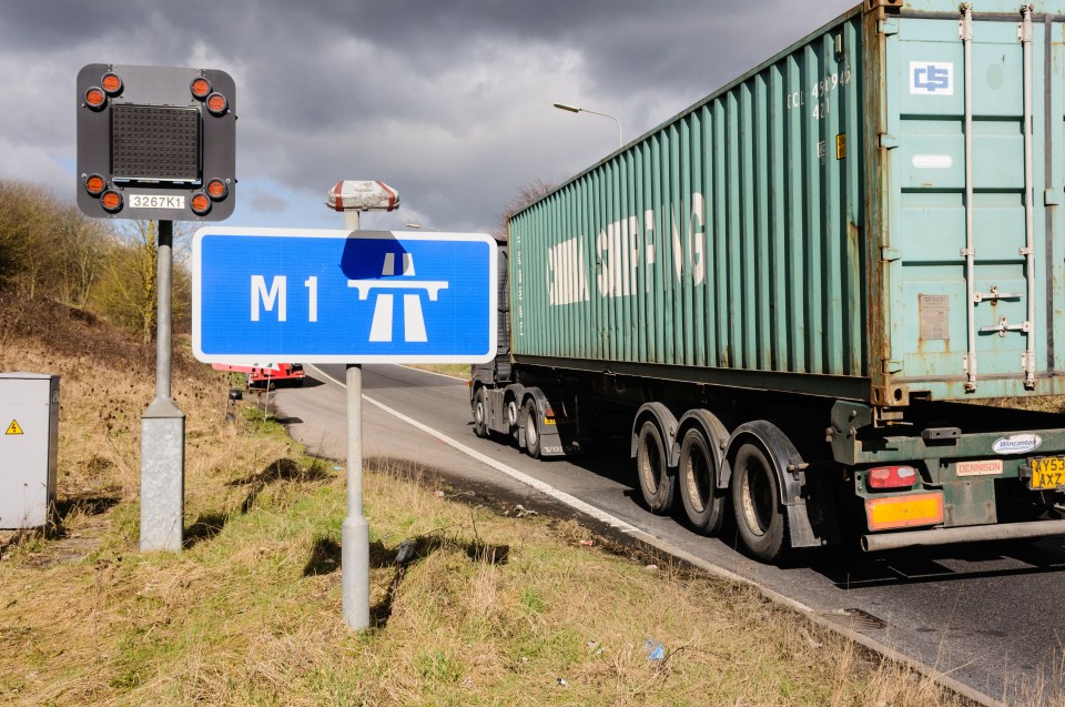 Lorry carrying a shipping container on the slip road to the M1 motorway.