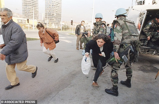 Sarajevo residents run along 'Sniper Alley' under the protection of French United Nations soldiers, 1994