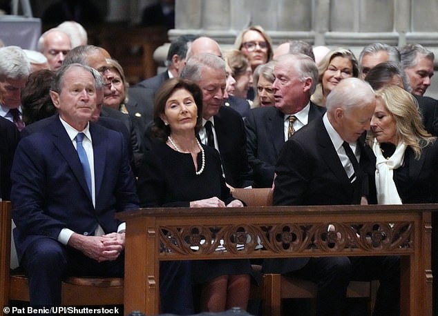 Dr. Biden (right) is captured whispering into her husband former President Joe Biden's ear as former President George W. Bush and First Lady Laura Bush (left) watch Dick Cheney's funeral services