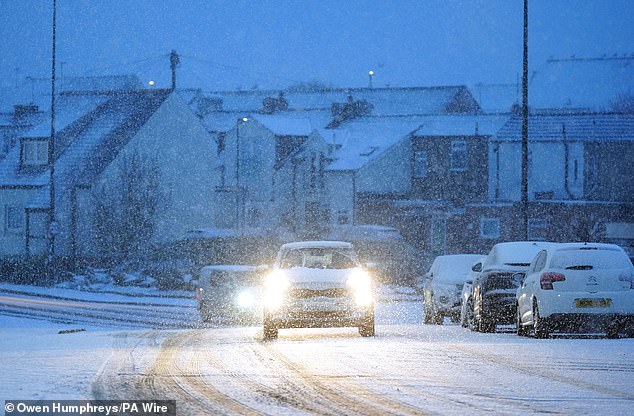 A car driving through the snowy conditions at Cullercoats in North Tyneside this morning