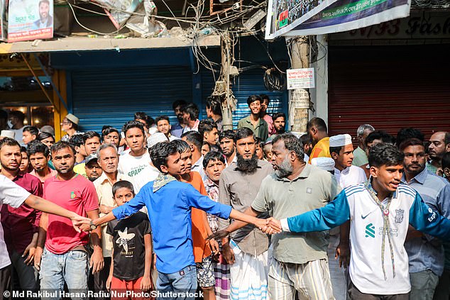A crowd gathers in front of the scene as at least three people are reported dead on the spot after the railing of the rooftop of a five-storey building collapses following an earthquake in the Kosaituli area of Armanitola in Dhaka, Bangladesh, on November 21, 2025