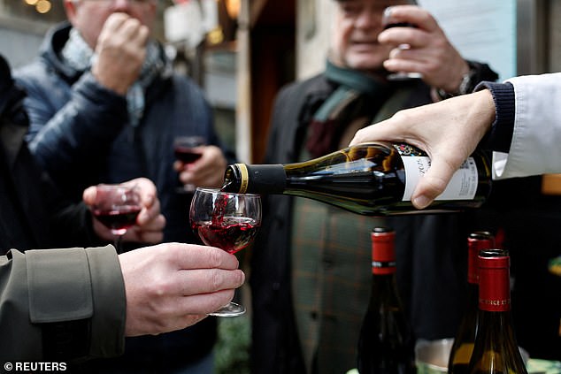 Pour vous, monsieur? A barman pours a glass of Beaujolais Nouveau in a bistrot in Paris