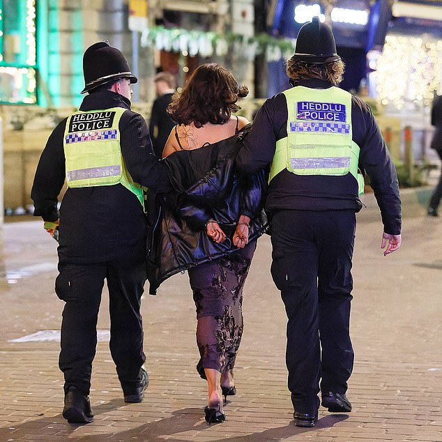 The night did not go to plan for everyone (pictured: a woman is led away in handcuffs by police)