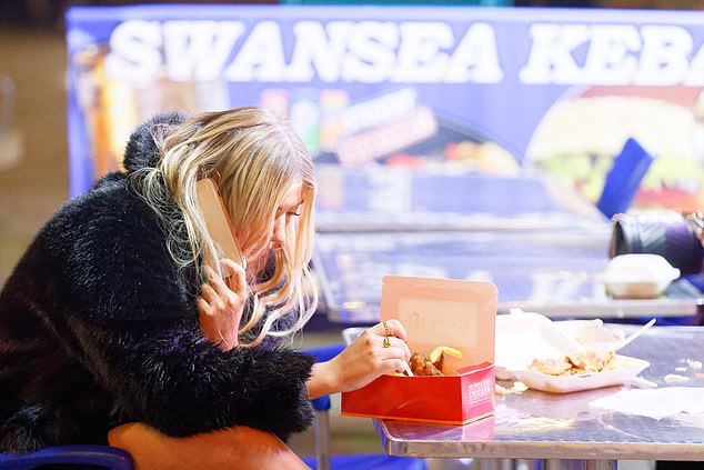 You've had your chips! A woman tucks into a box of fried chicken towards the end of her night